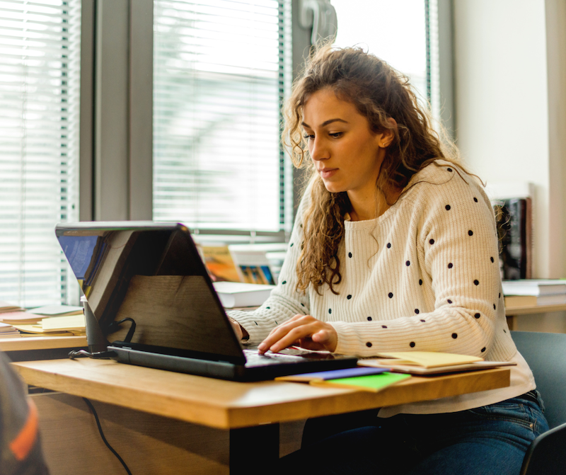 person-sitting-on-their-laptop